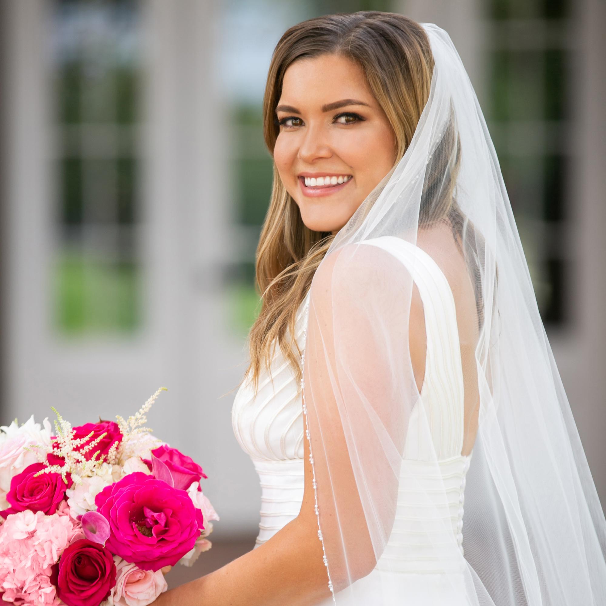 Smiling bride with red floral bouquet
