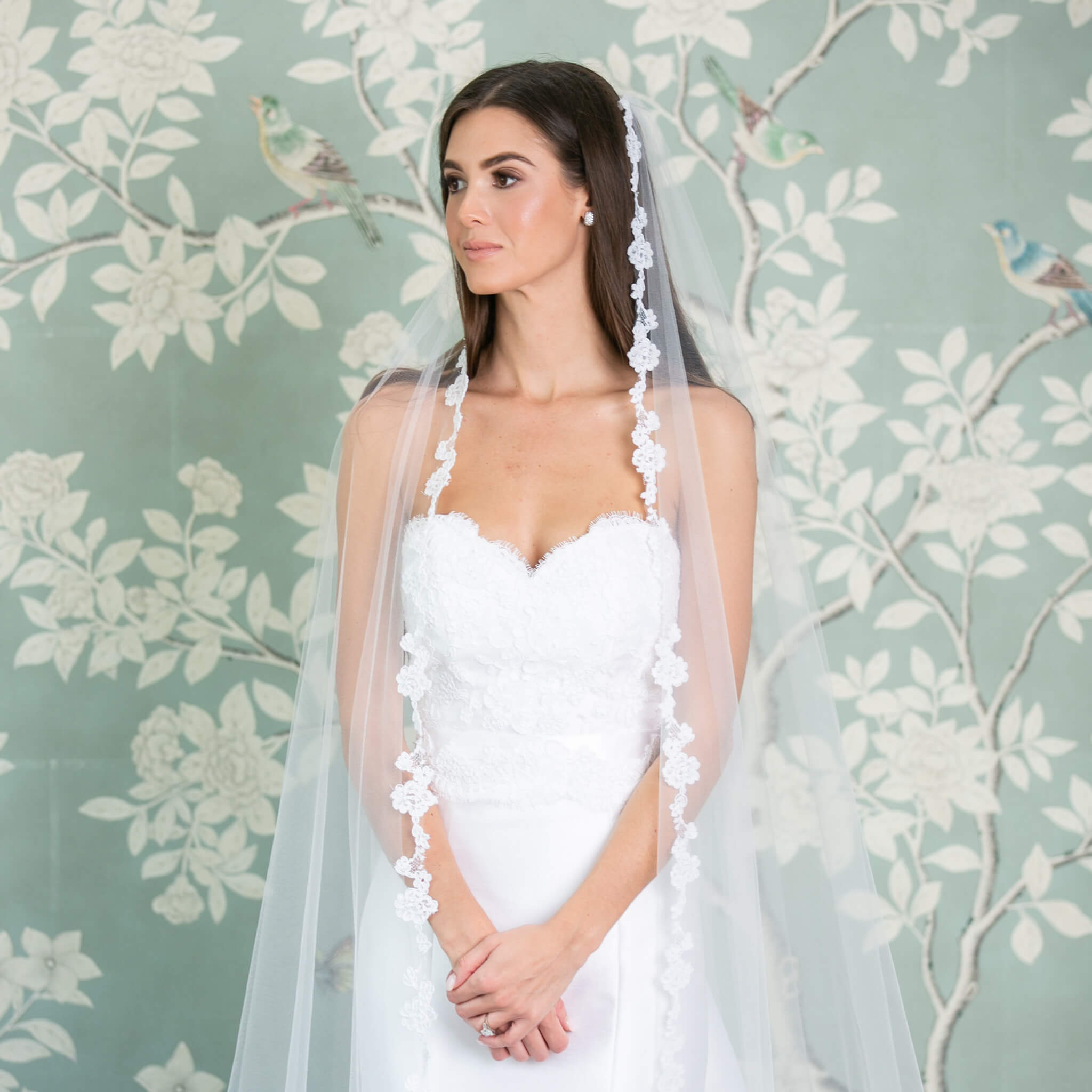 Bride posing in front of light blue wallcovering