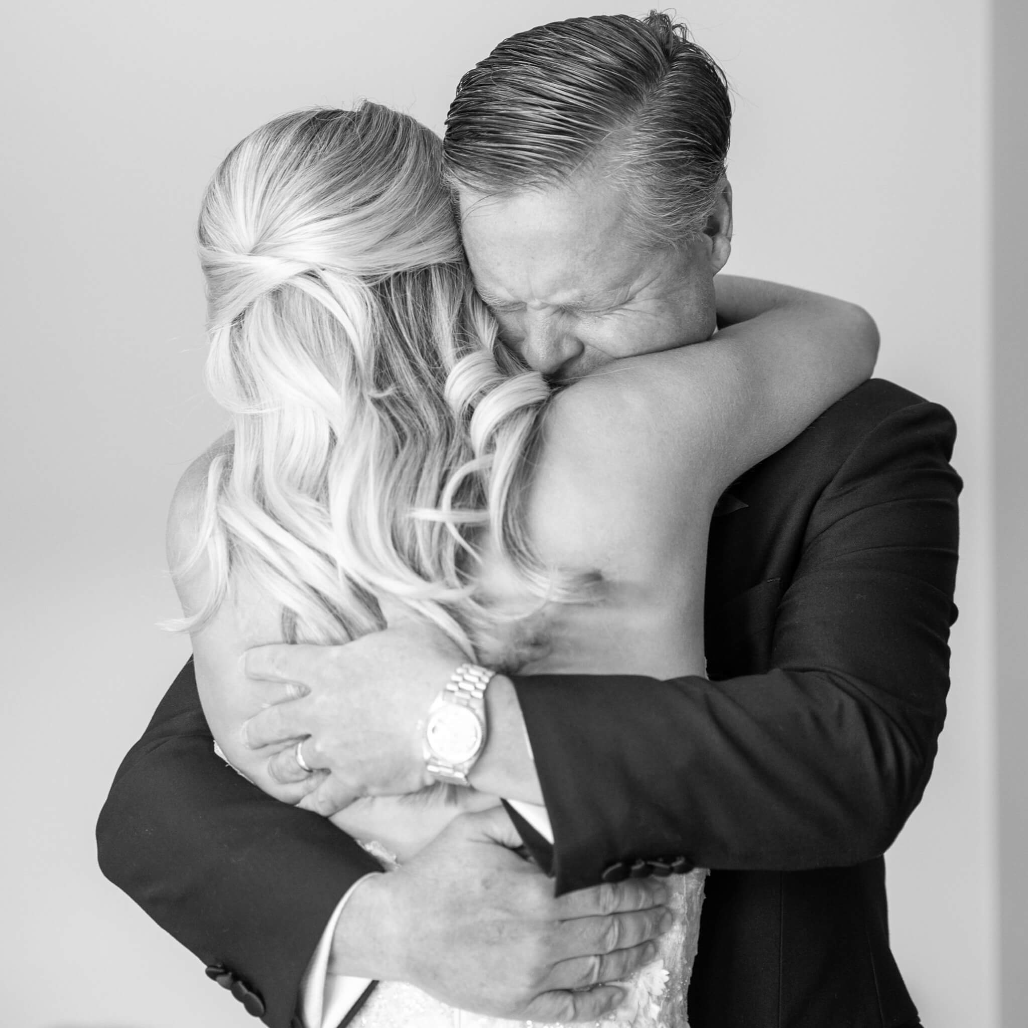 Black and white photo of the bride and groom hugging